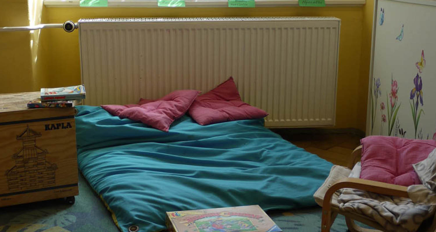 Gemütliche Lese- und Ruhe-Ecke im Hort Blasewitz mit bunten Kissen, Decken und Spielen.